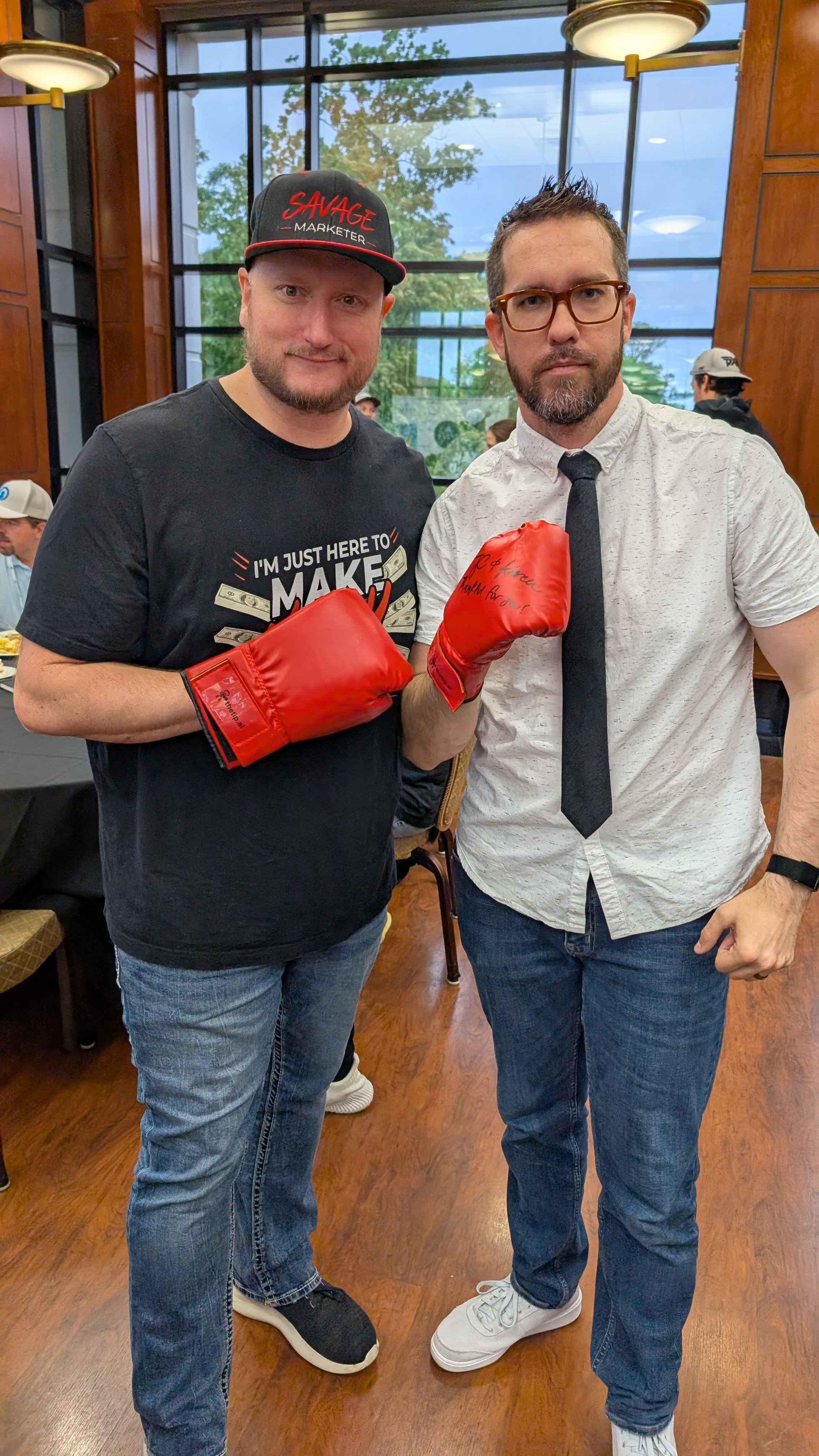 Jeff J Hunter and Jonathan Mast wearing signed boxing gloves given to them after The Great AI Debate.